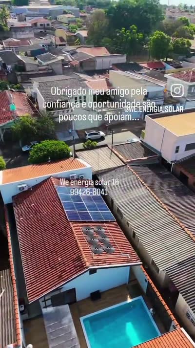 Vista de drone de uma casa com piscina e placas solares no telhado de telha cerâmica